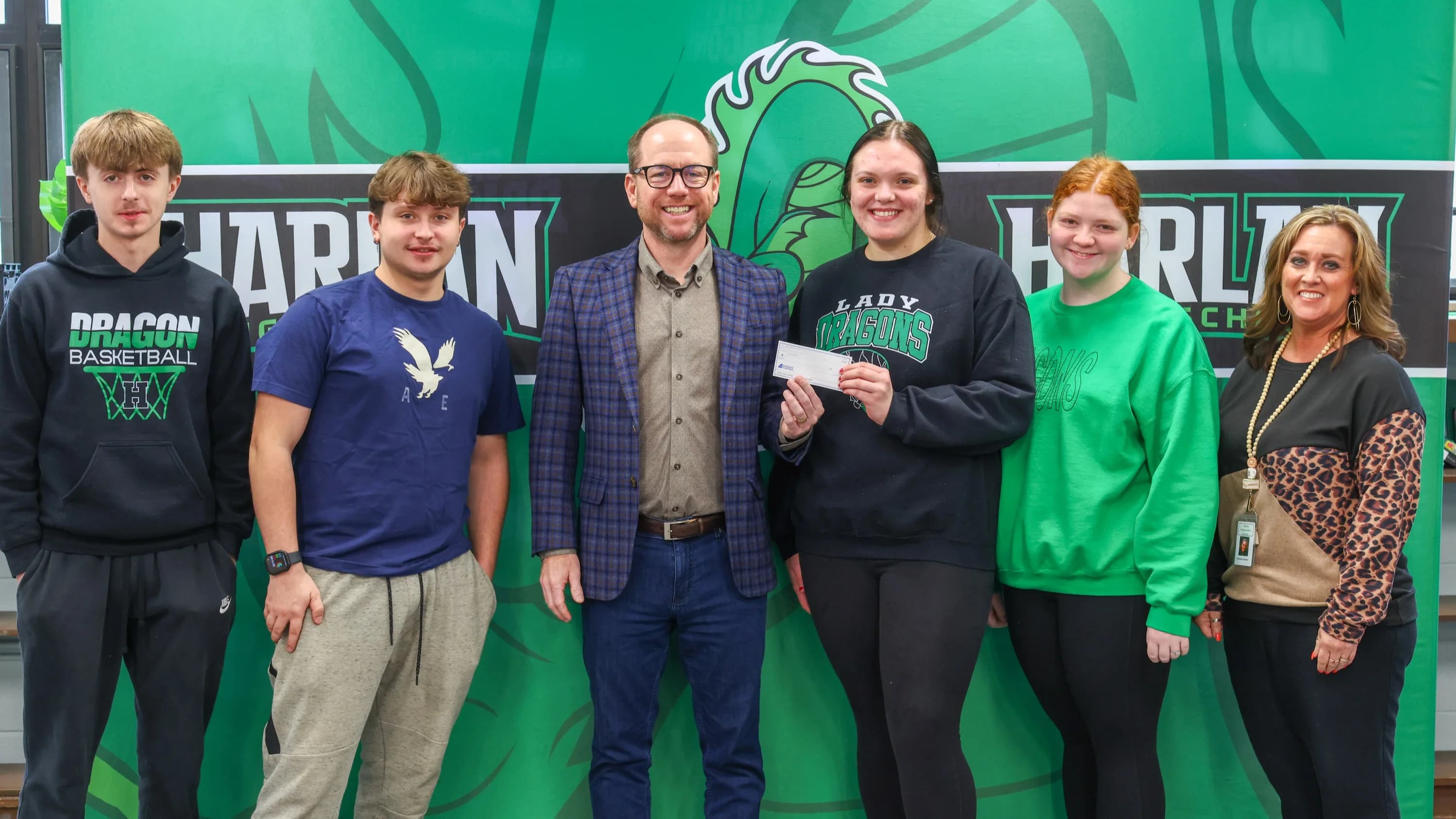 Boom founder presenting seed capital check to students